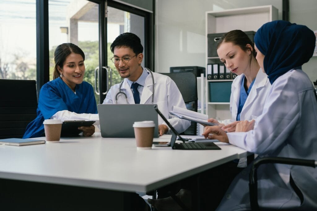 Medical, meeting and laptop for team in office in discussion, brainstorming and planning.