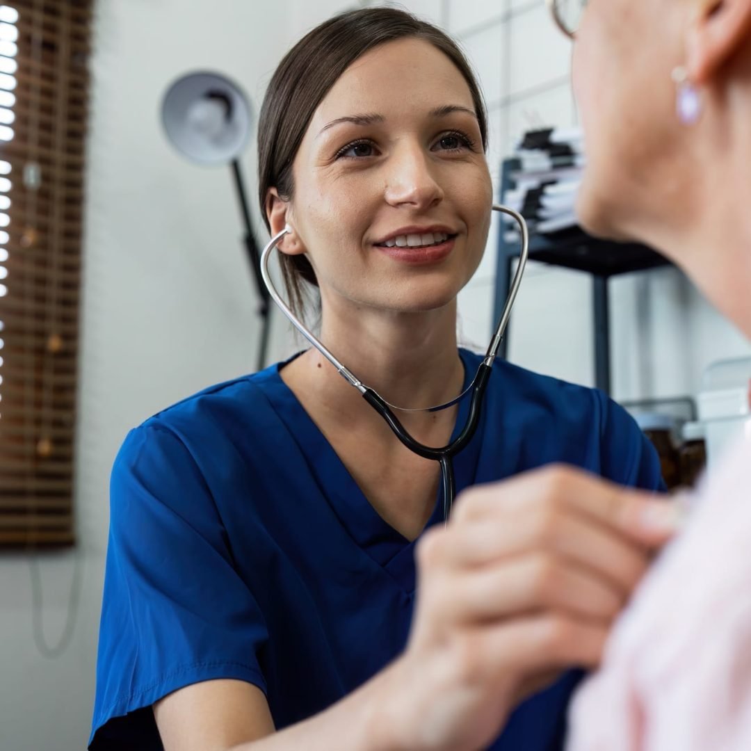 Doctor listens to heartbeat of older of retirement age to check their heart rate Doctor listens to heartbeat of older of retirement age to check their heart rate