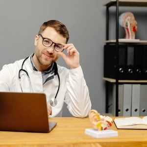 Doctor sitting at desk with laptop