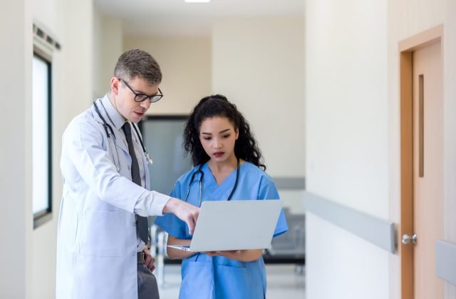 Doctor using laptop computer at hospital.