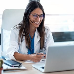 female-doctor-talking-with-colleagues-through-a-video-call-with-a-laptop-in-the-consultation-