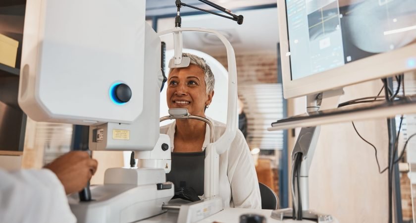 Machine, senior woman and test eyes in office, optometry and healthcare for vision, smile and conve