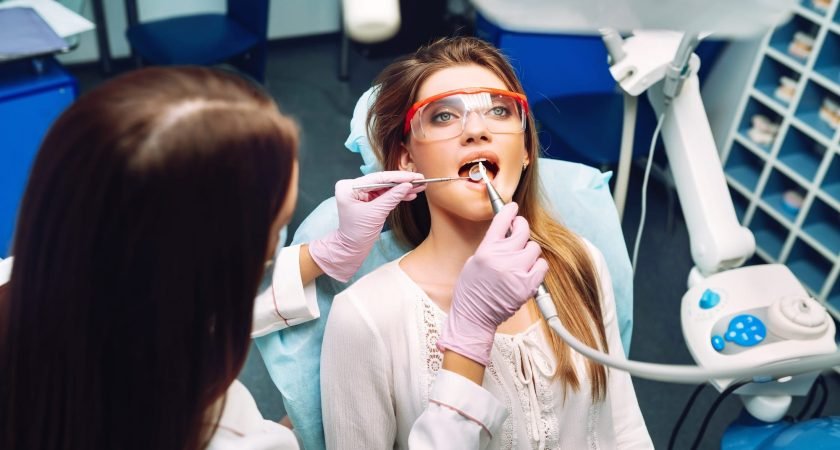 Young woman at the dentist's chair during a dental procedure. Overview of dental caries prevention.